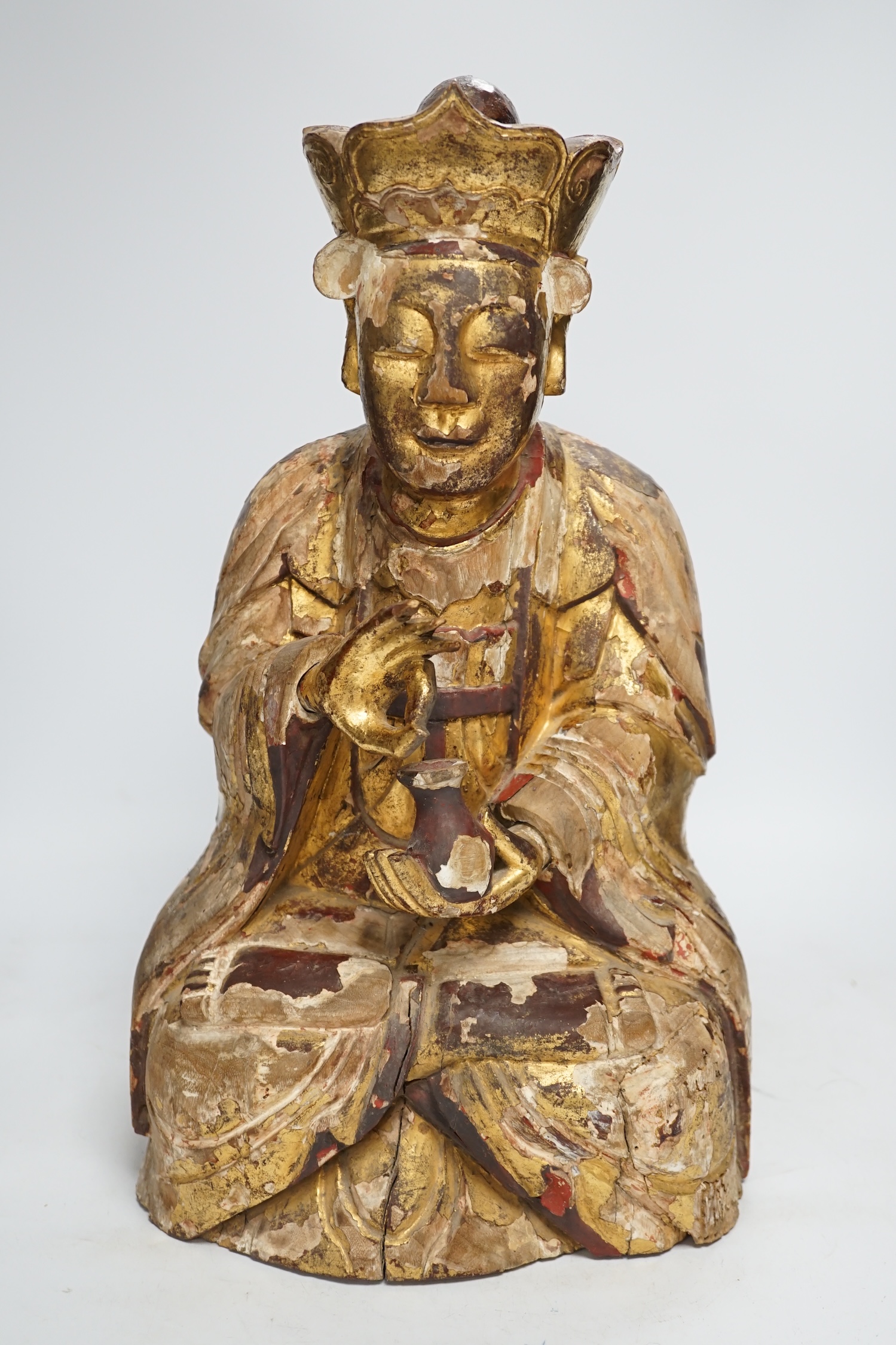 A Chinese gilt lacquered wooden figure of Buddha, possibly Yuan to Ming, 42cm high. Condition - poor to fair, losses to lacquer overall